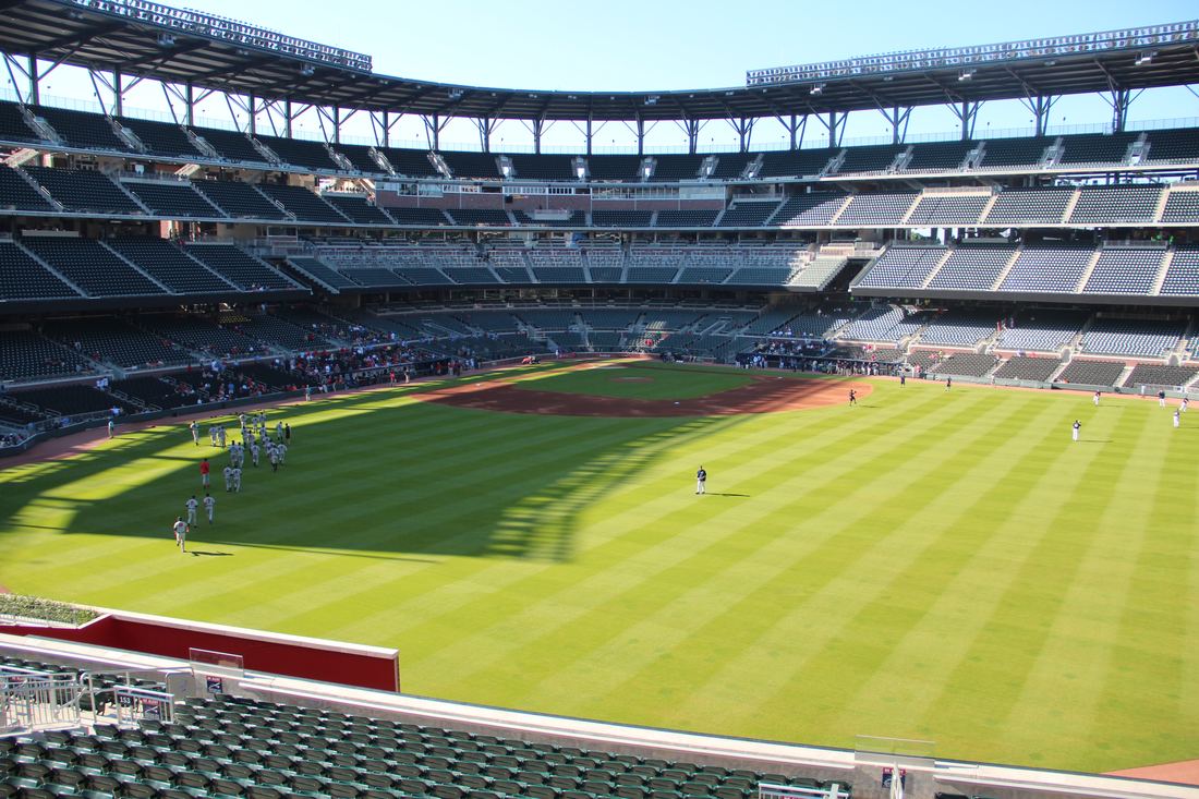 View across the green outfield grass toward the grandstands of the ballpark