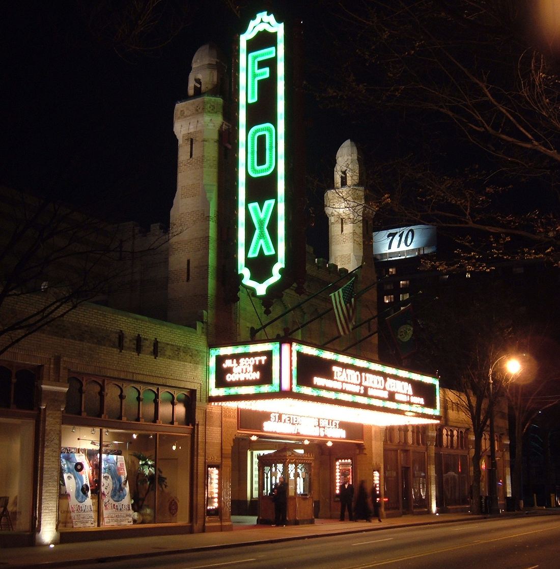 The Fox Theatre's vertical FOX sign and marquee glowing on Peachtree Street at night