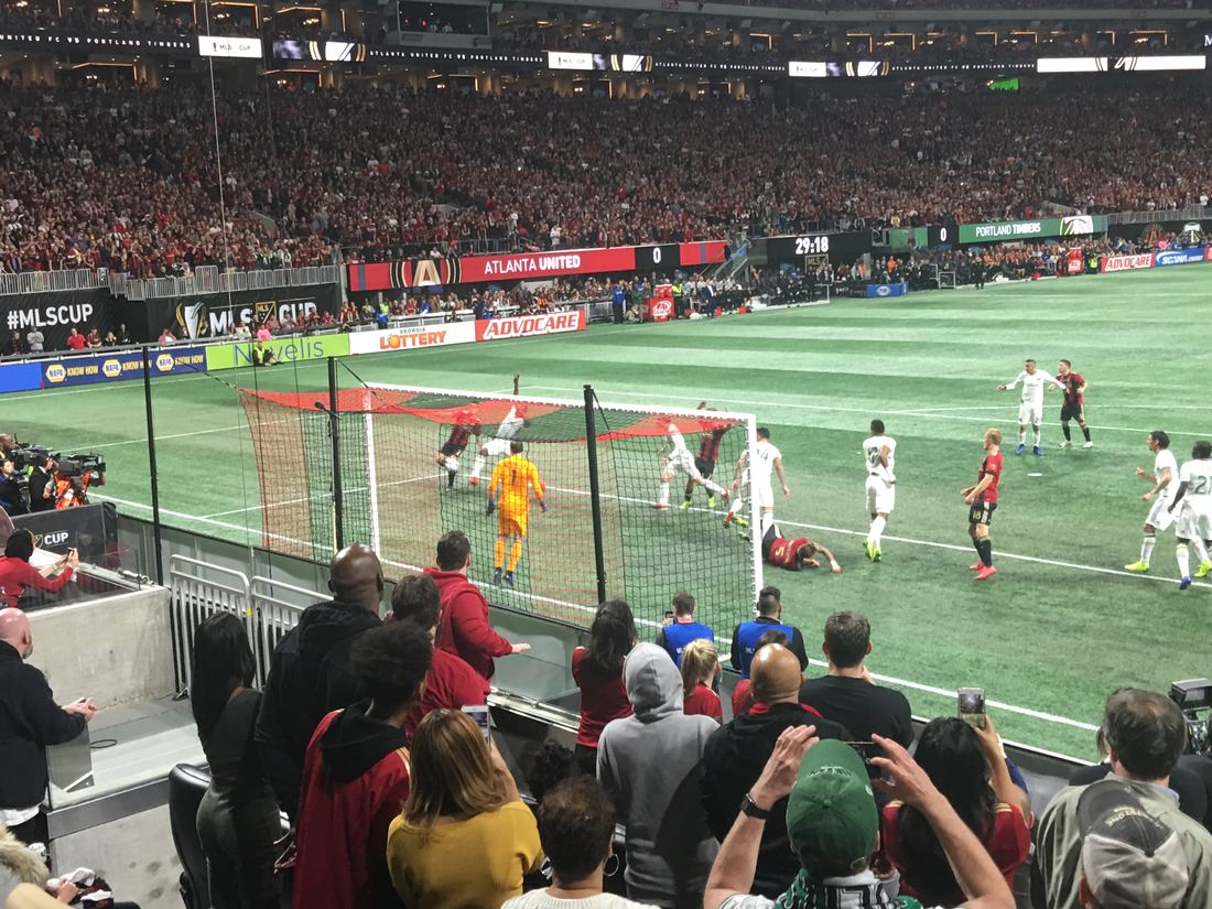 Fans watch from the front row as Atlanta United attack the goal during MLS Cup 2018