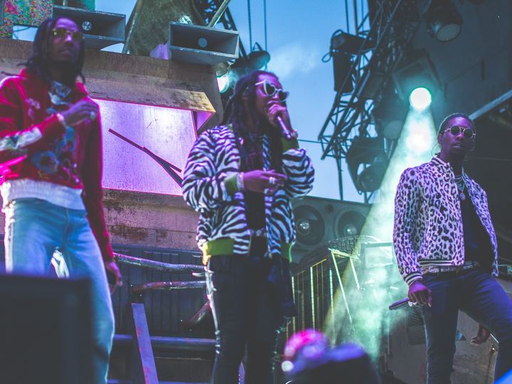 Quavo, Takeoff and Offset of Migos performing together on an outdoor festival stage