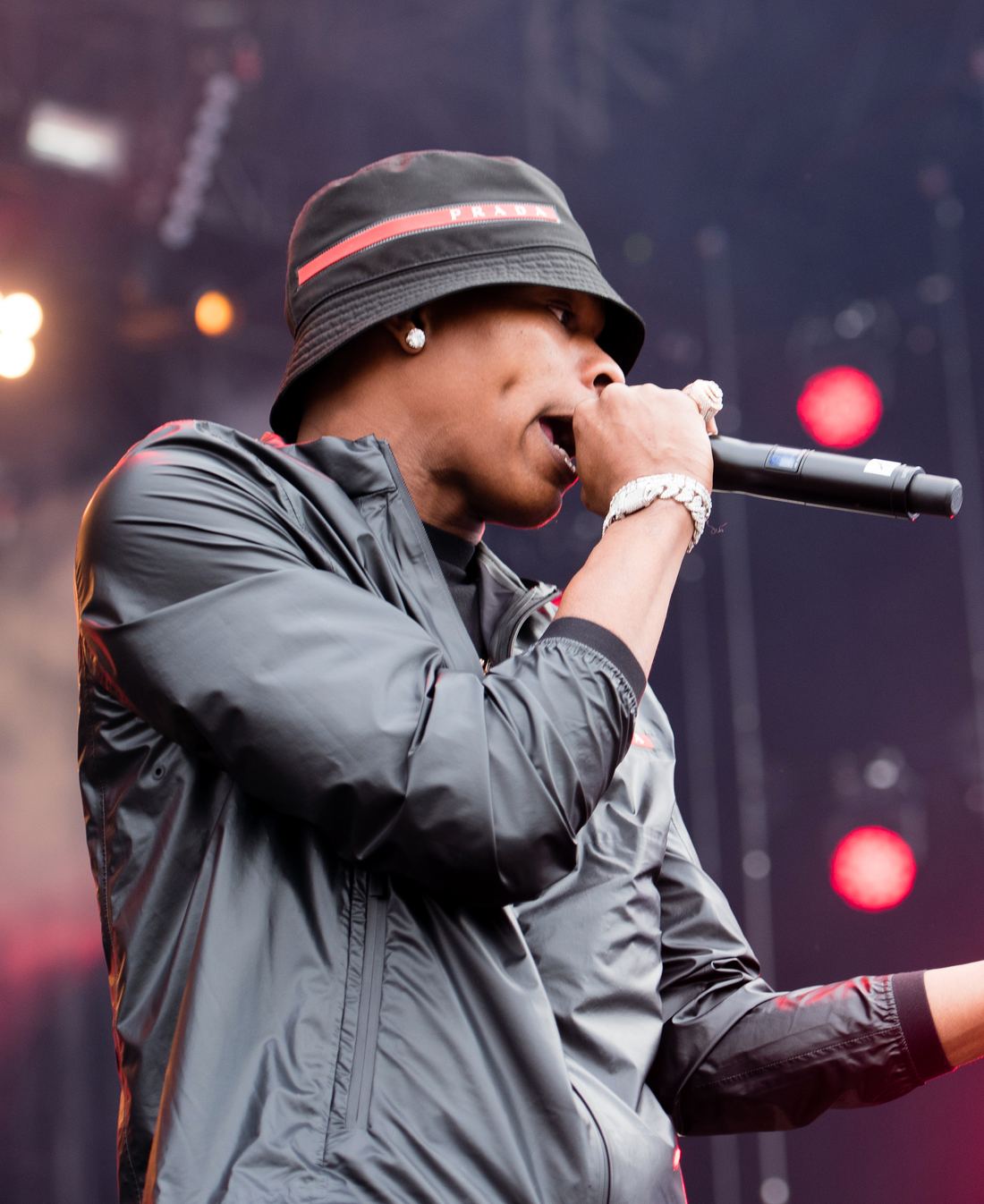 Lil Baby in a bucket hat rapping into a microphone on stage