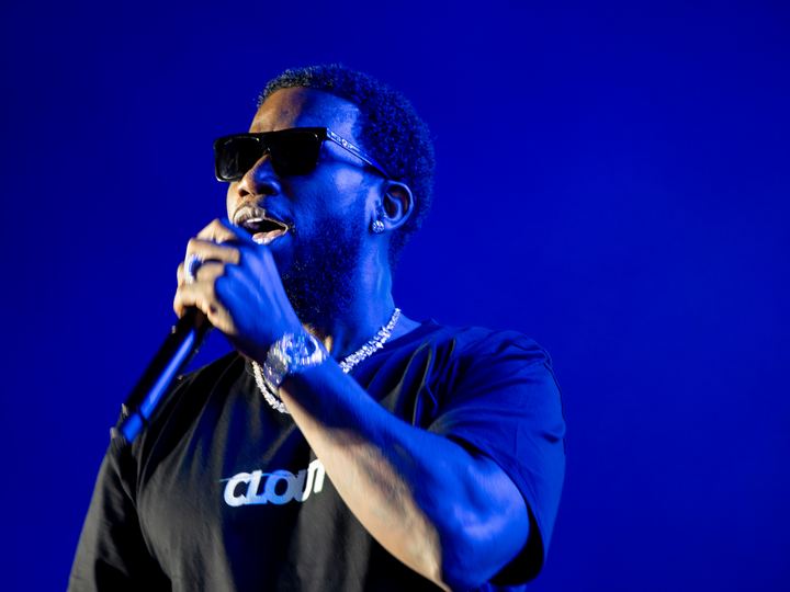 Gucci Mane performing on a blue-lit festival stage