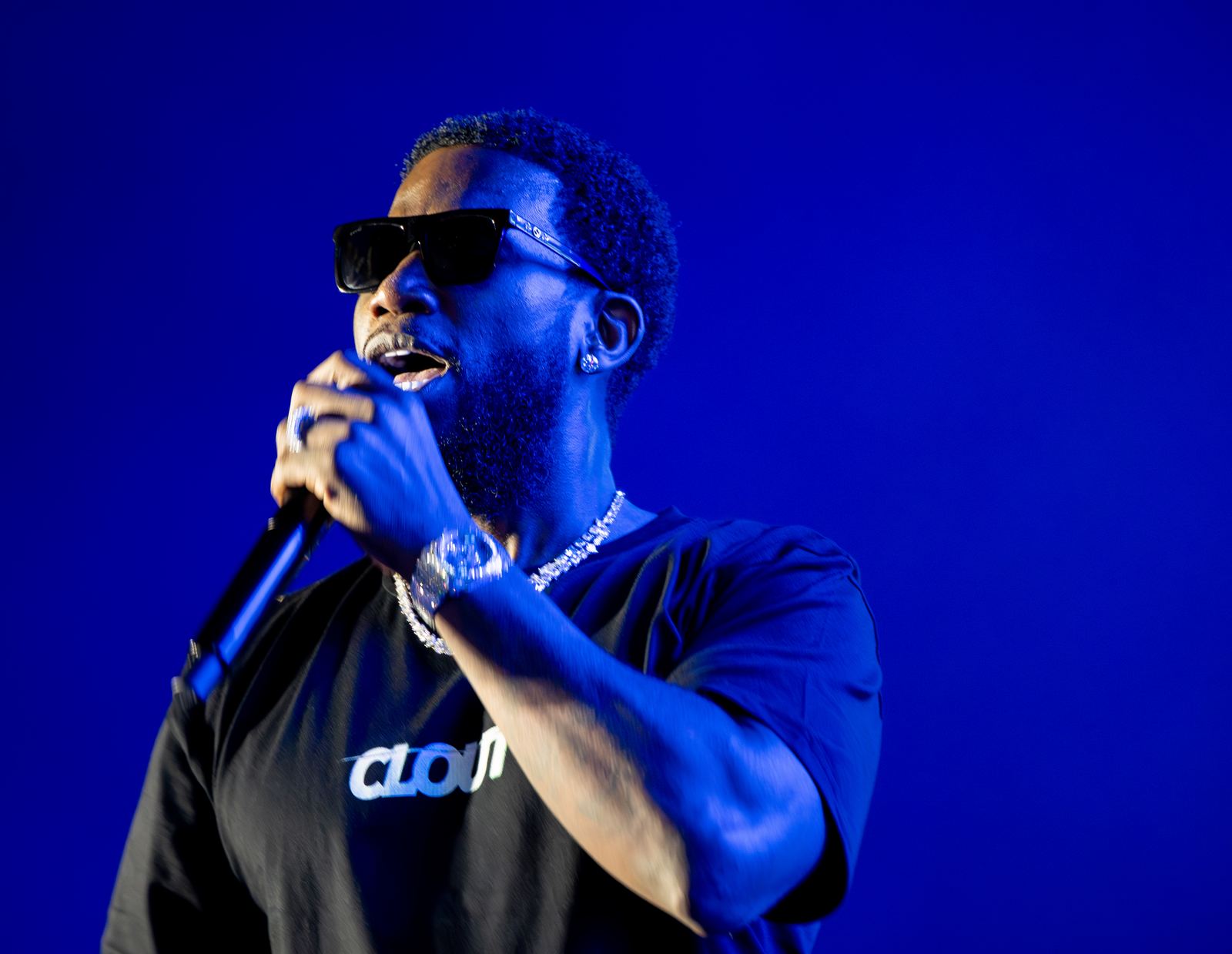 Gucci Mane performing on a blue-lit festival stage